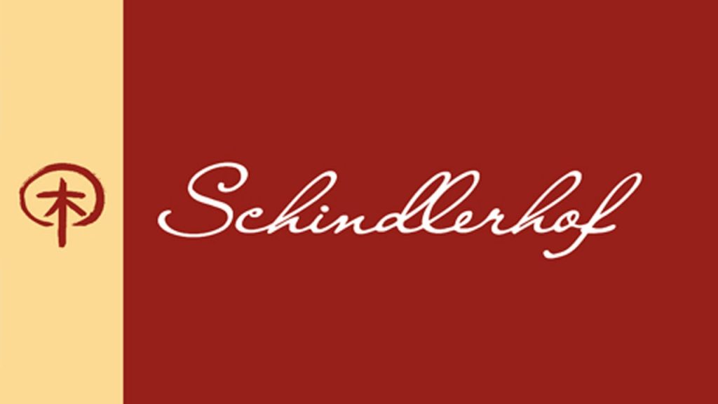 Schindlerhof logo on a red field with a pale left stripe and a circular tree emblem beside white cursive text Schindlerhof